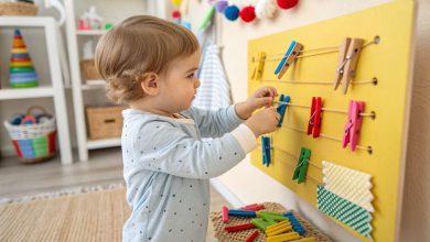 Fine Motor Activities for Toddlers (2025) – Simple, Fun Ways to Build Skills Through Play 7 Toddler using colorful clothespins on a sensory board – fine motor activities for toddlers at home