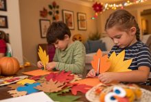 Kids making Thanksgiving crafts with paper turkeys, leaves, and pumpkins