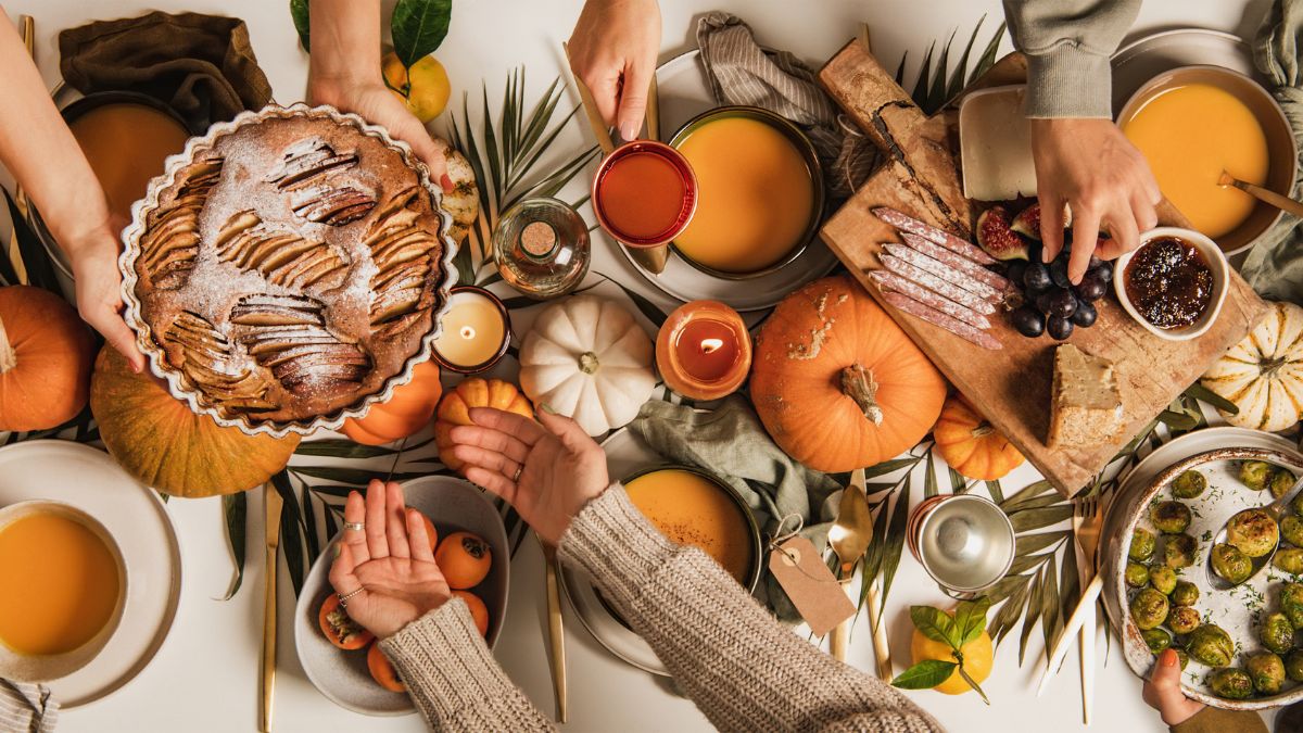 30+ Friendsgiving Theme Ideas 2025: Cozy, Creative & Aesthetic Party Inspirations for Hosting an Unforgettable Celebration 1 friendsgiving theme ideas table setup with cozy fall decorations and friends laughing